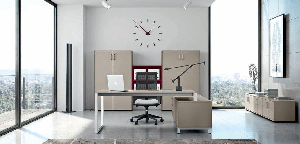 Un ufficio moderno e minimalista con scrivania in legno chiaro, sedia ergonomica, armadietti e orologio a parete, in una stanza luminosa.
