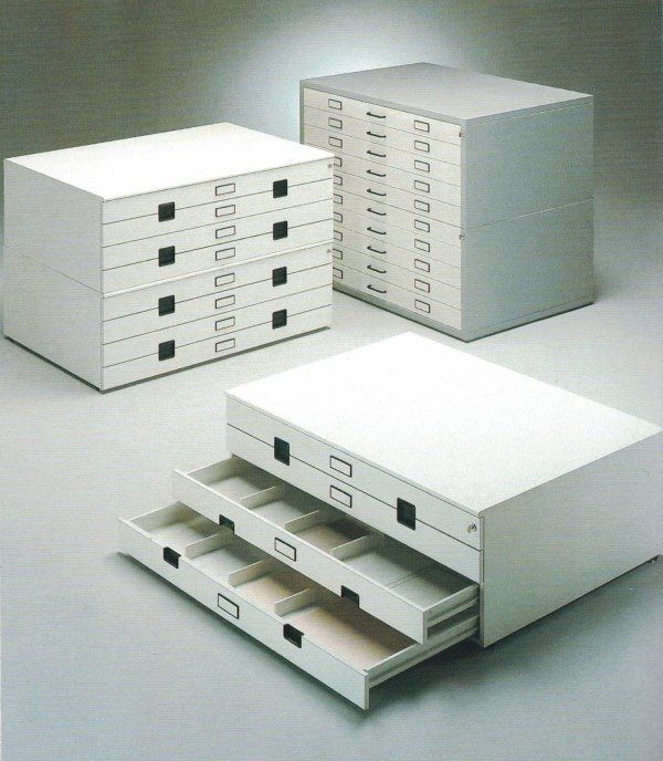 Tre armadietti modulari bianchi con cassetti impilabili, uno dei quali mostrato parzialmente aperto con divisori interni.