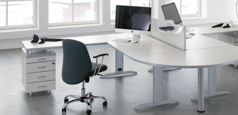 Scrivanie da ufficio moderne di colore bianco con paravento, sedia da ufficio grigio scuro e cassettiera mobile abbinata.
