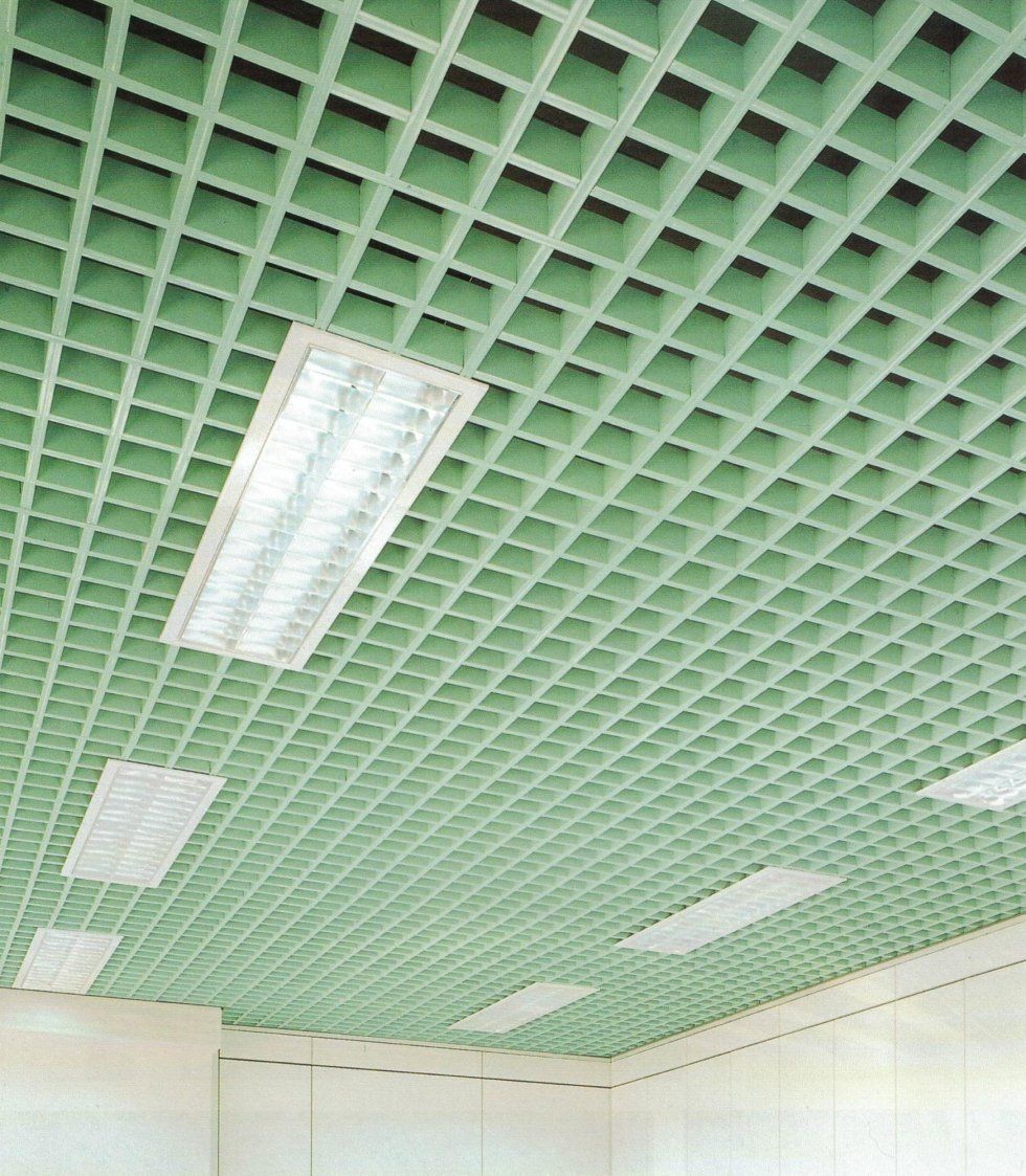 Un soffitto a griglia a celle aperte di colore verde chiaro con diverse luci fluorescenti rettangolari incassate.