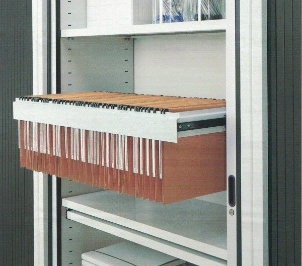 Un cassetto estraibile all'interno di un mobiletto in metallo bianco, contenente cartelle sospese con una finitura effetto legno.