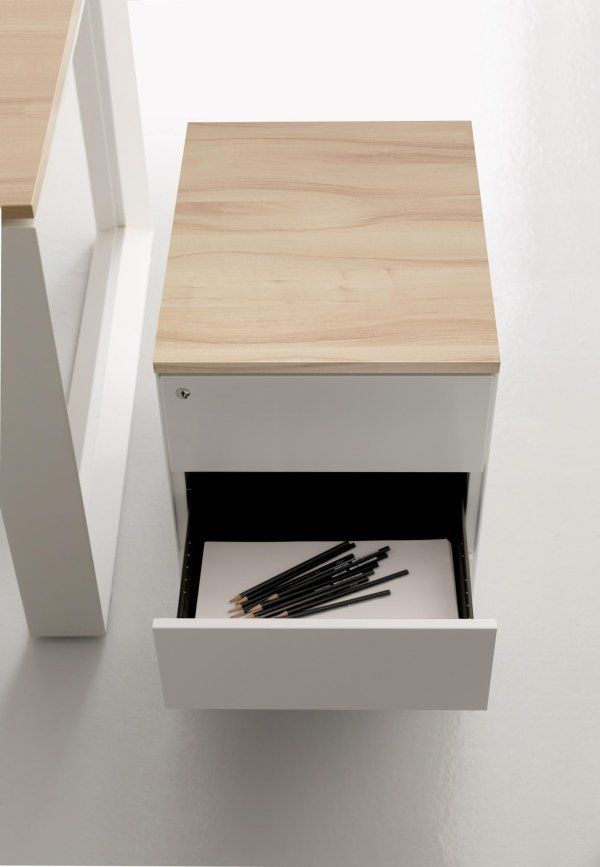 Una moderna scrivania bianca con piano effetto legno e un cassetto aperto contenente un gruppo di matite nere.