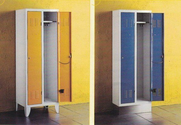 Due armadietti metallici, uno con ante e gambe gialle, l'altro con ante blu e base piena, addossati a pareti gialle.