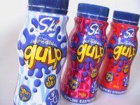 Three bottles of gulp yogurt are sitting next to each other on a table.