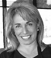 A woman is smiling in a black and white photo.