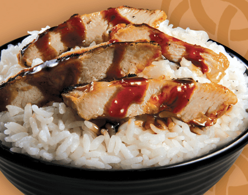 A bowl of rice with meat and sauce on top