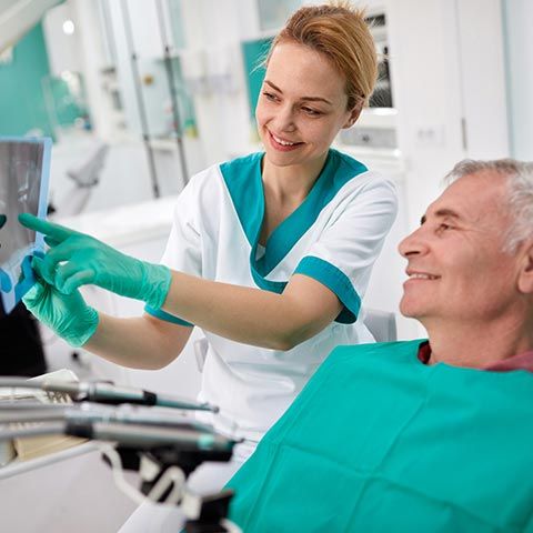 Dentist Showing Teeth Problems on Dental X-Ray — Grand Rapids, MI — Dentures In a Day Dentist Showing Teeth Problems on Dental X-Ray — Grand Rapids, MI — Dentures In a Day