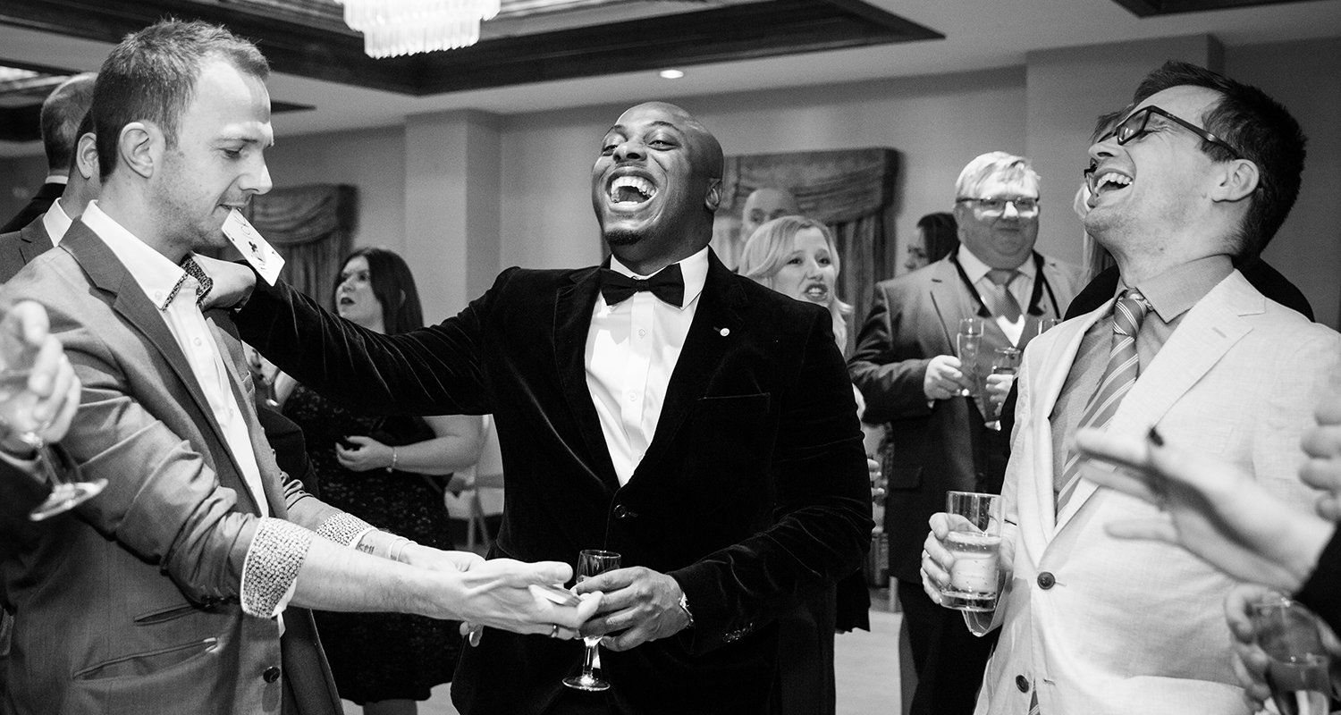 Event photography Berkshire, guests laughing at magician
