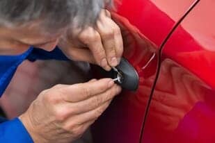 Man Repairing Lock of a Red Car - Transponder Keys in Albuquerque, NM