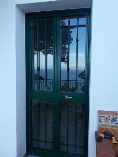 portone esterno verde con inferriate
