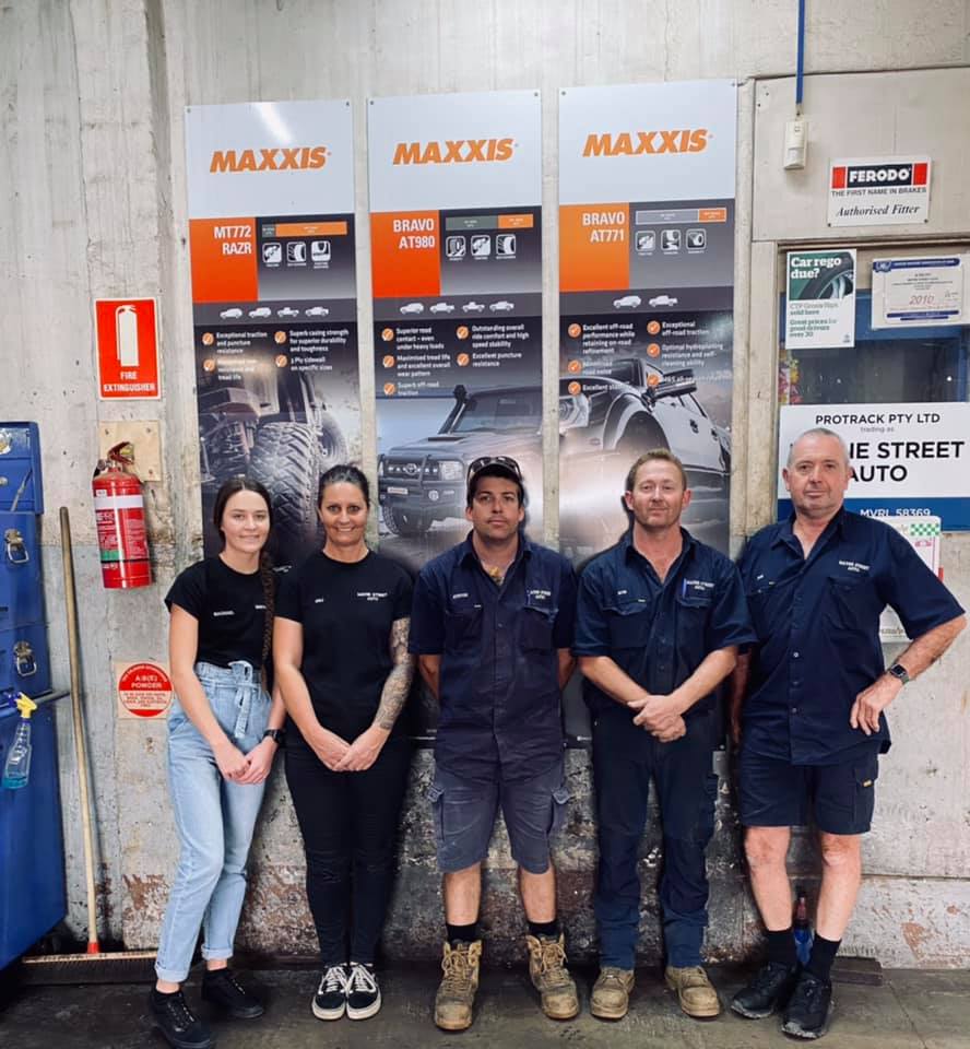 A Group of People Standing in Front of Signs for Maxxis — Mayne Street Auto in Gulgong, NSW