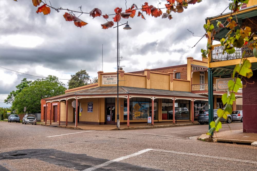 A Group of People Standing in Front of a Wall With Signs That Say Maxxis — Mayne Street Auto in Gulgong, NSW