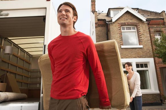 man and woman carrying a couch
