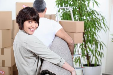 man and woman carrying a carpet