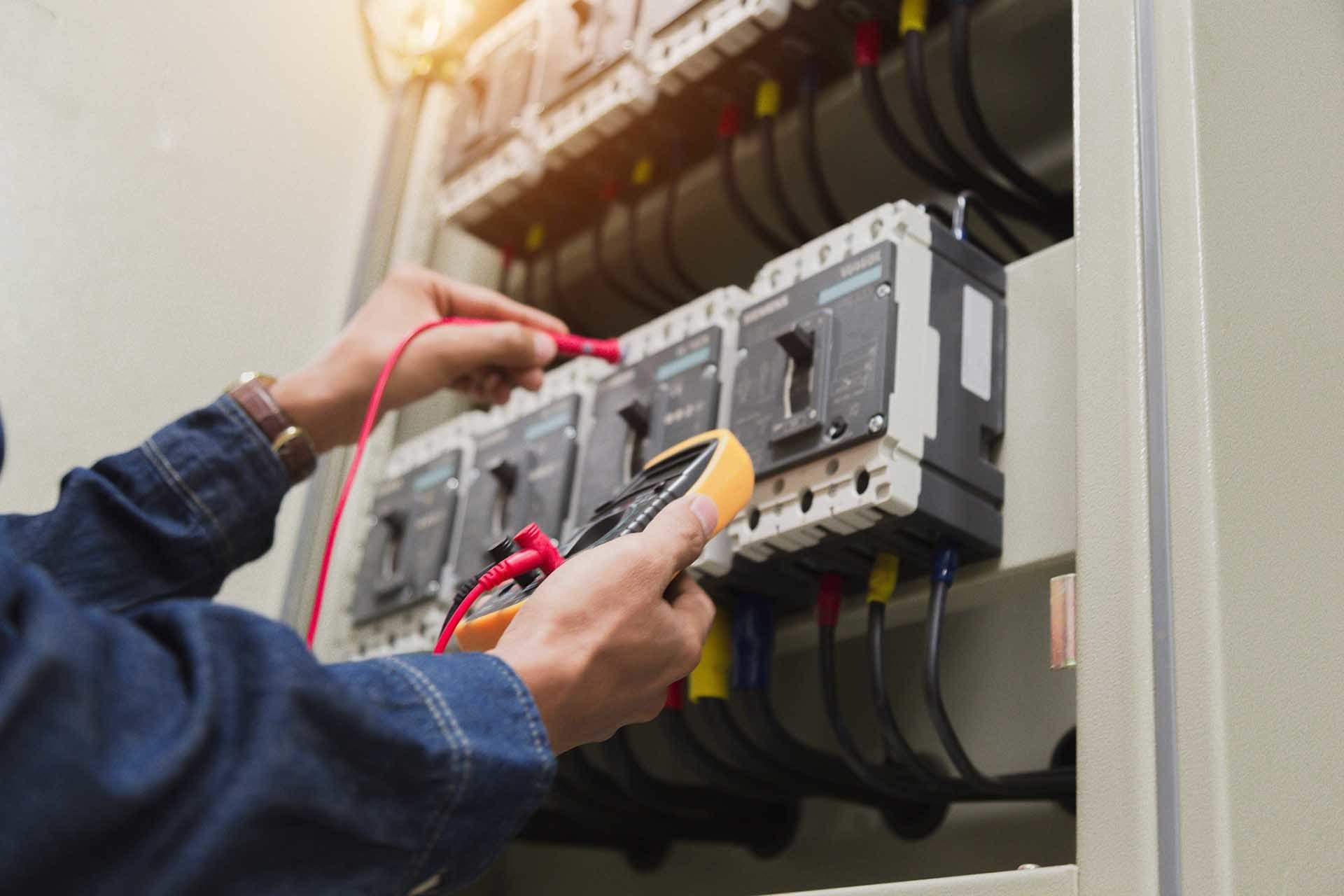 Electrician With Tester Measuring Voltage — Forrest, IL — RTJ Electric Electrician With Tester Measuring Voltage — Forrest, IL — RTJ Electric