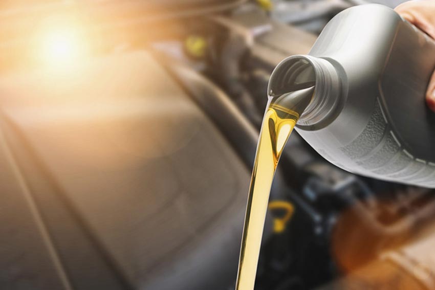 A mechanic topping up the break fluid on a Mercedes Benz.