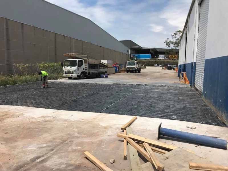 concrete construction next to large warehouses