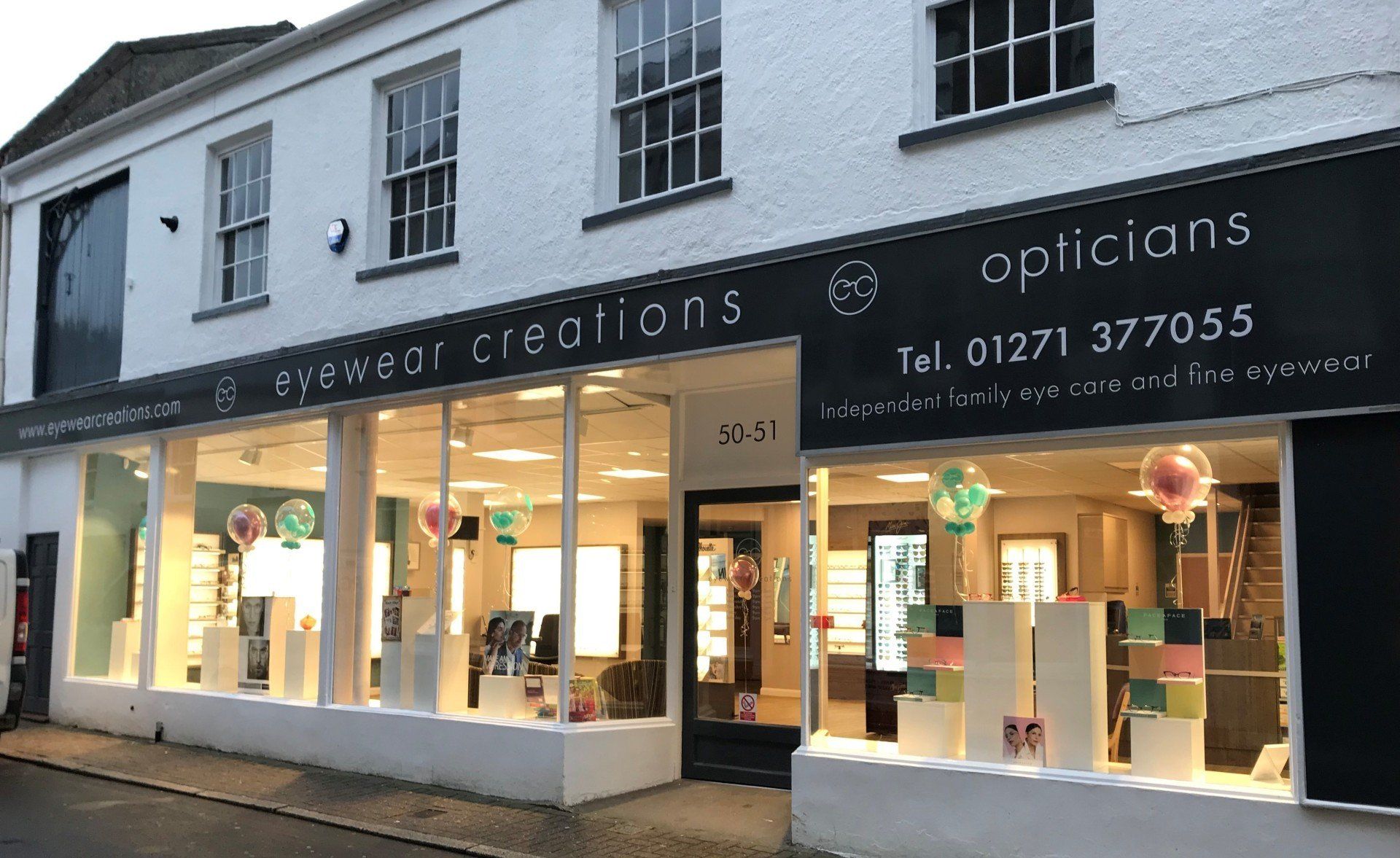 External view of Eyewear Creations opticians during the evening.