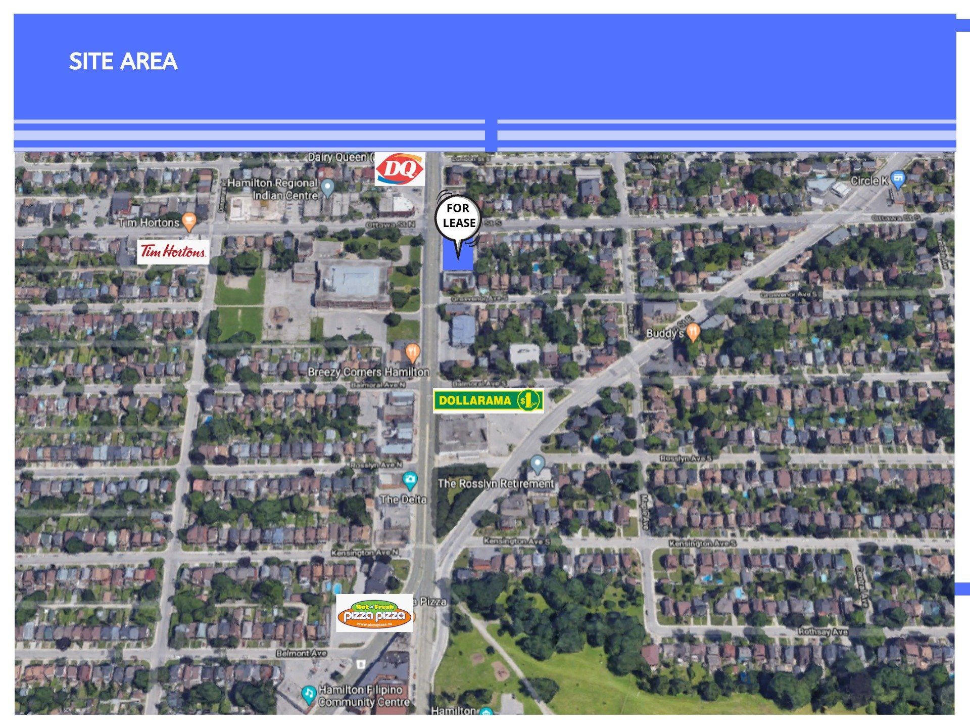 Aerial view showing a marked site area on a city street, surrounded by residential housing and local businesses.