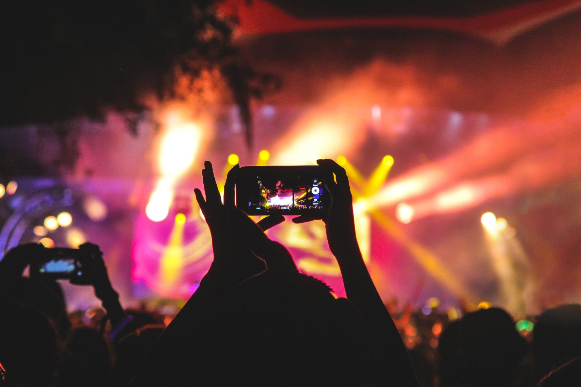 holding mobile up at music event