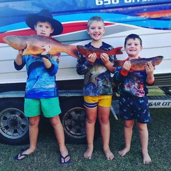three kids holding fish