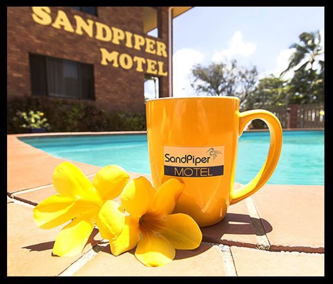 flowers and mug in front of sandpiper motel