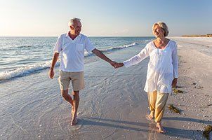 old couple walking by the beach
