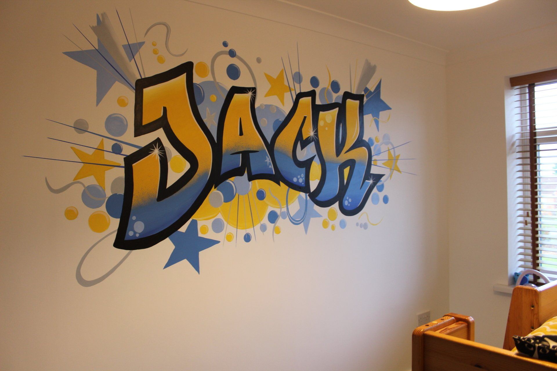Jack graffiti style kids mural in blues and yellows stars and circles 