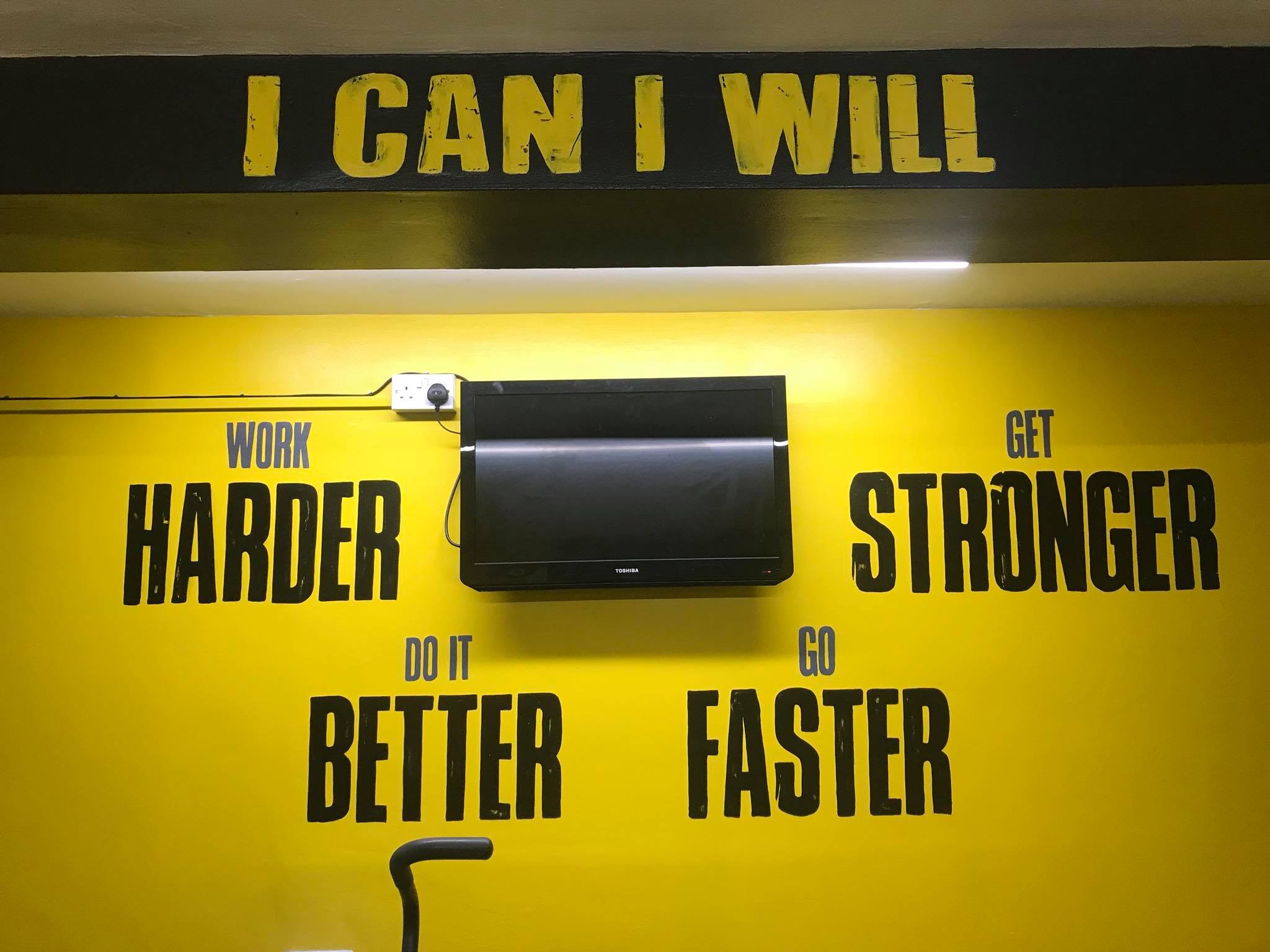 Gym murals inspirational words like harder stronger better faster