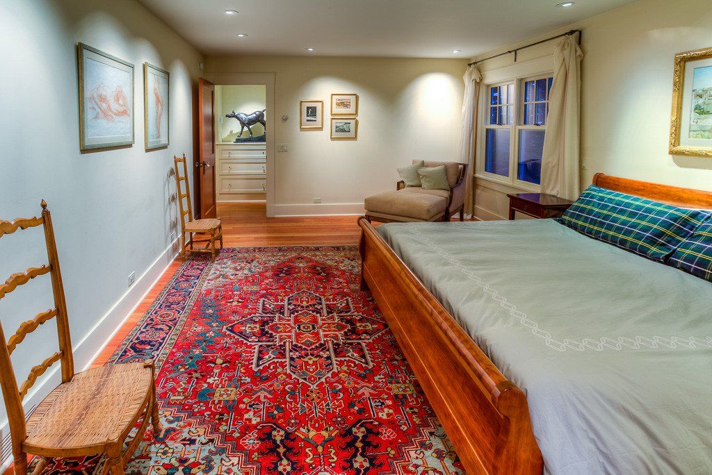 A bedroom with a large bed and a rug