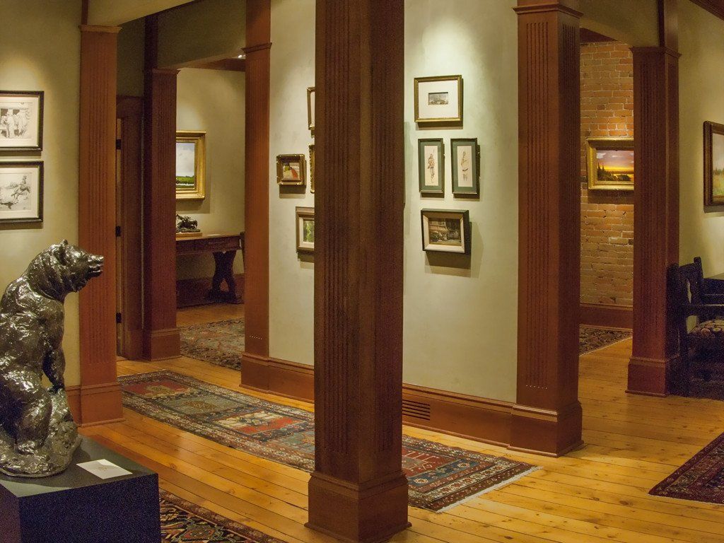 A hallway with wooden pillars and pictures on the wall