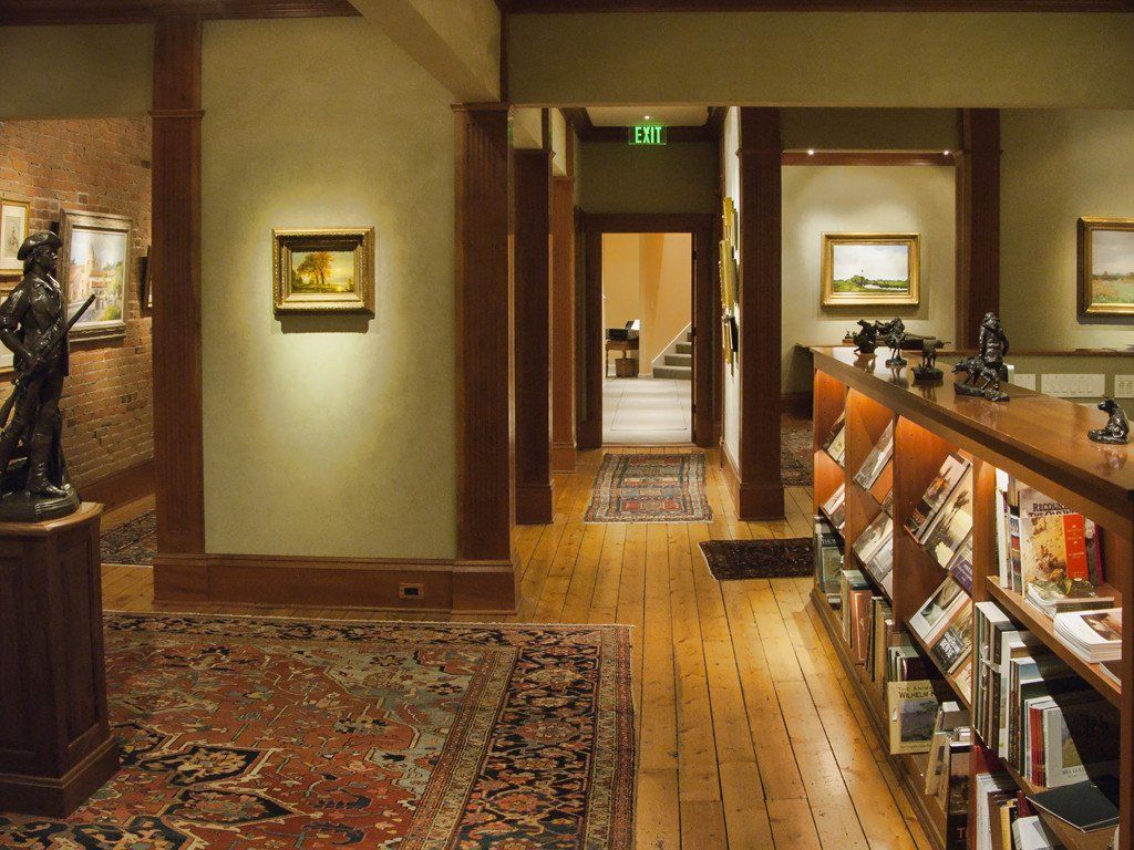 A hallway in a museum with paintings on the wall