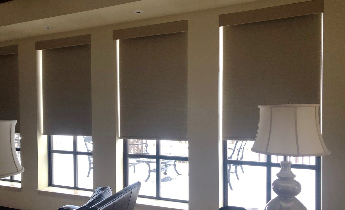 A living room with a lot of windows and a lamp