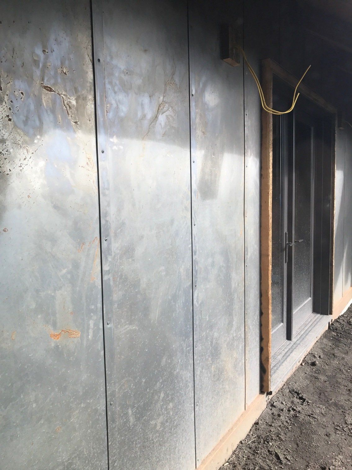 A gray wall with a chain hanging from it