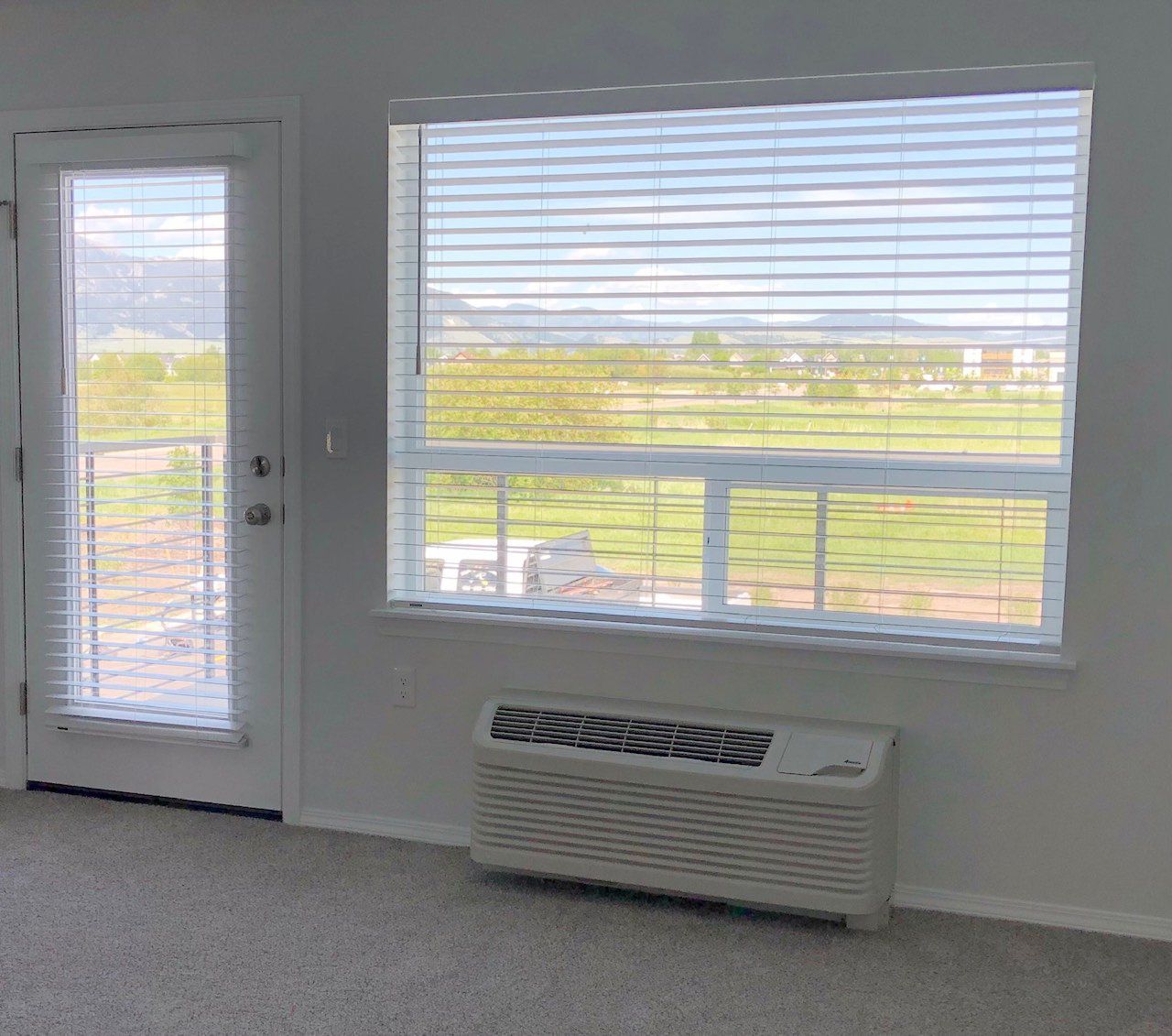 An empty room with a window and a door.