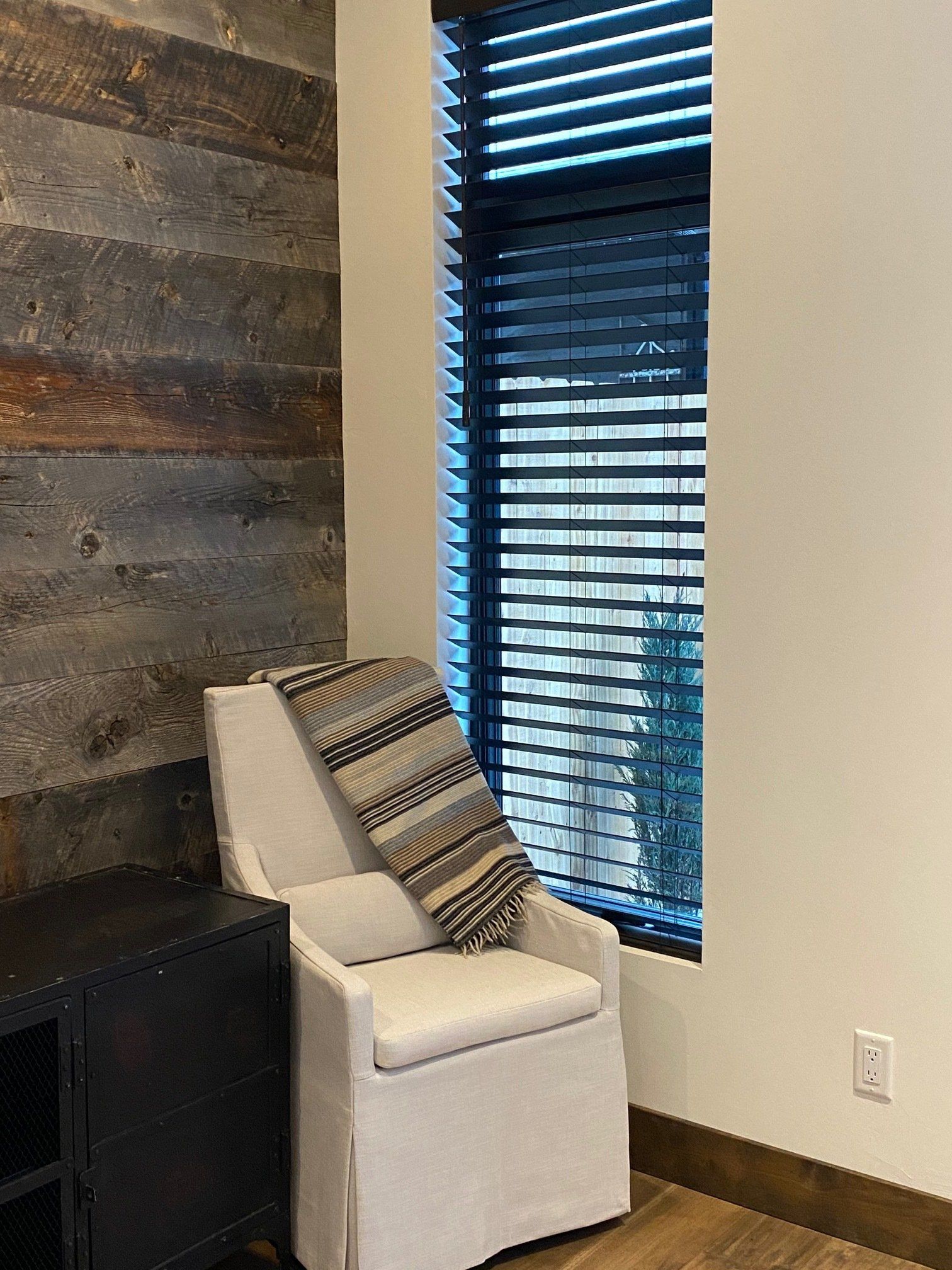 A chair is sitting in front of a window with blinds.