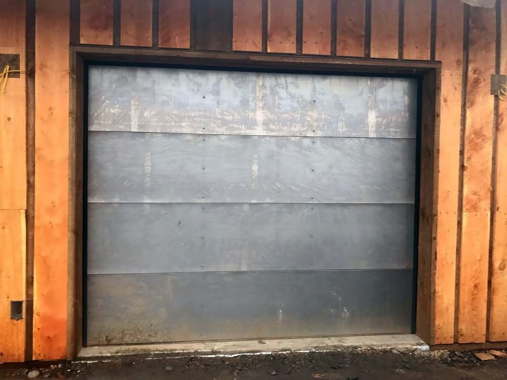 A garage door with a wooden wall behind it