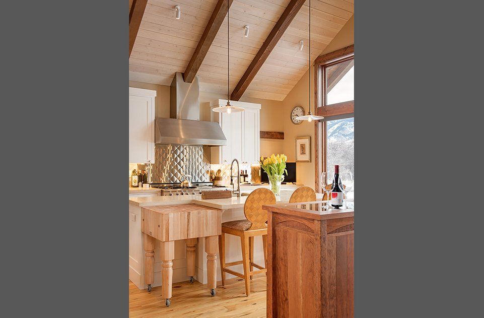 A kitchen with wooden cabinets and a wooden island