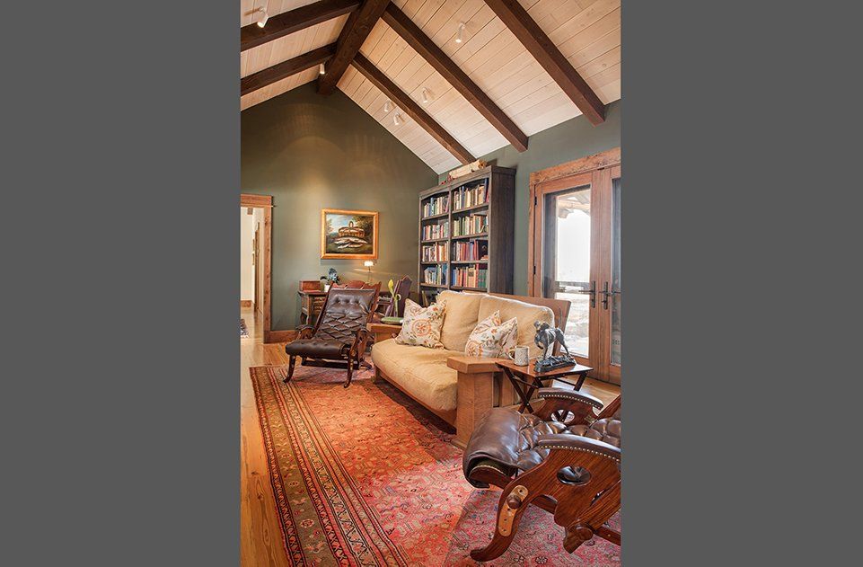 A living room with a vaulted ceiling and a couch and chairs