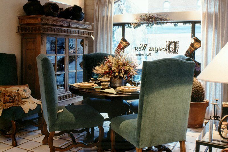 A dining room with a table and chairs in front of a window with the letter d on it