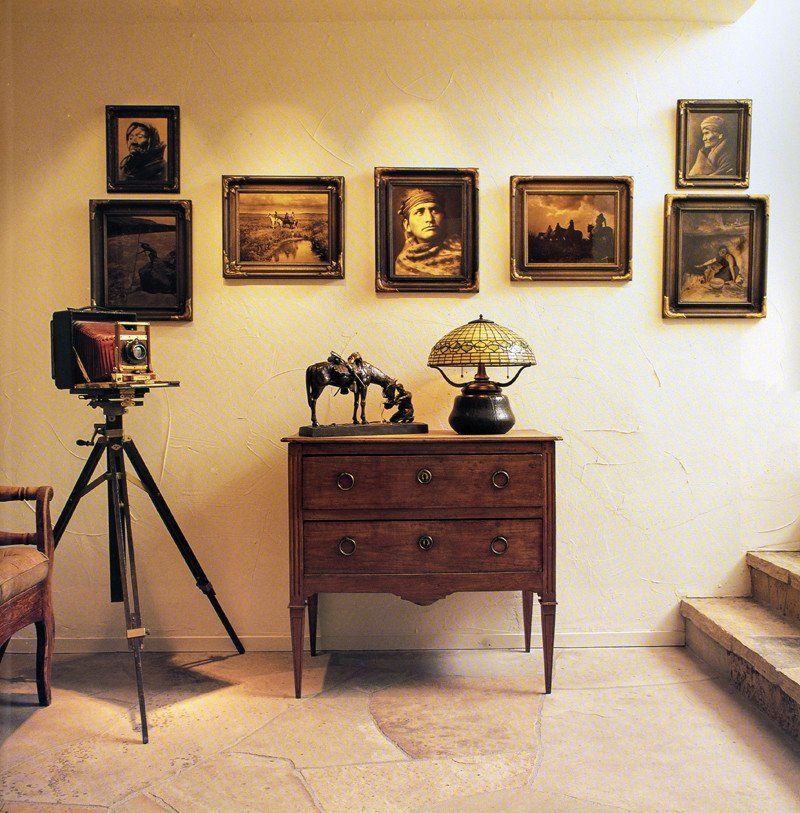 A room with pictures on the wall and a dresser
