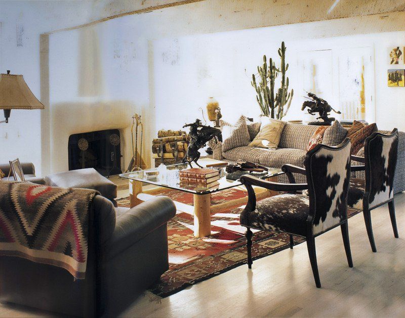 A living room with a couch and chairs and a glass coffee table