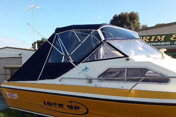 yellow and white boat with dark canopy