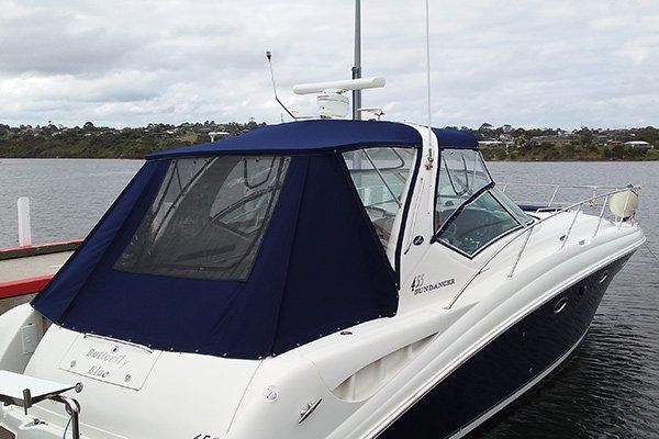 white boat with dark blue canopy on water