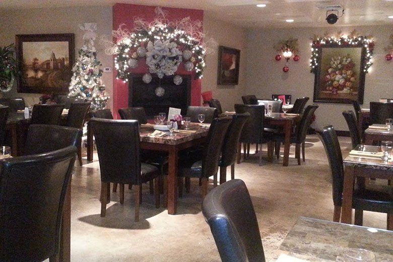 A restaurant with tables and chairs decorated for christmas