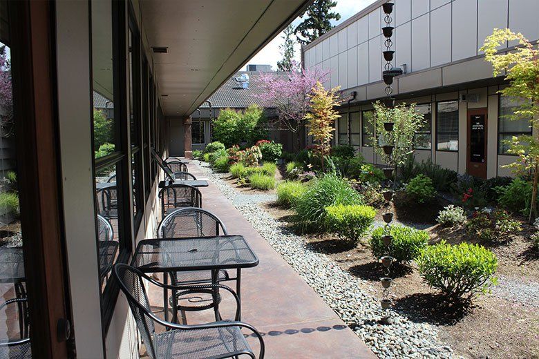 A patio with tables and chairs in front of a building