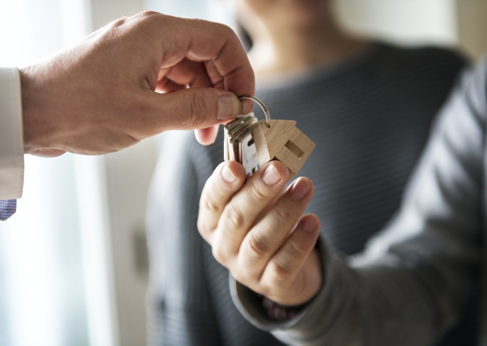 Man Hand Holding House Key — French Lick, IN — Brooks Galloway Real Estate Man Hand Holding House Key — French Lick, IN — Brooks Galloway Real Estate