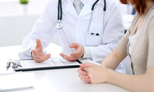 un medico che gesticola e una donna accanto