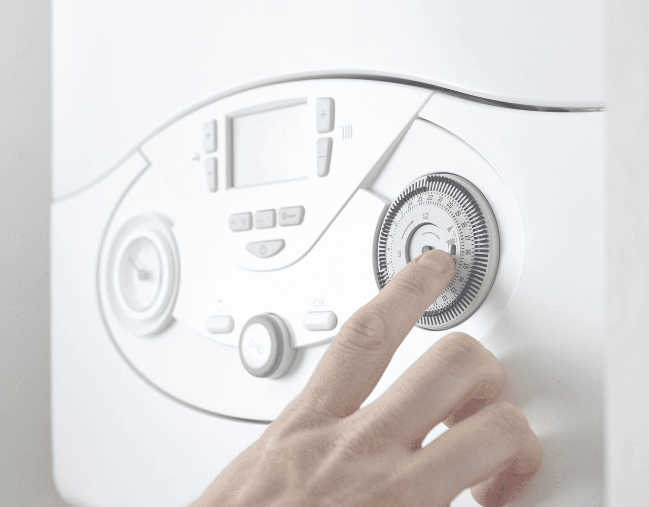 A person is adjusting a thermostat with their finger.