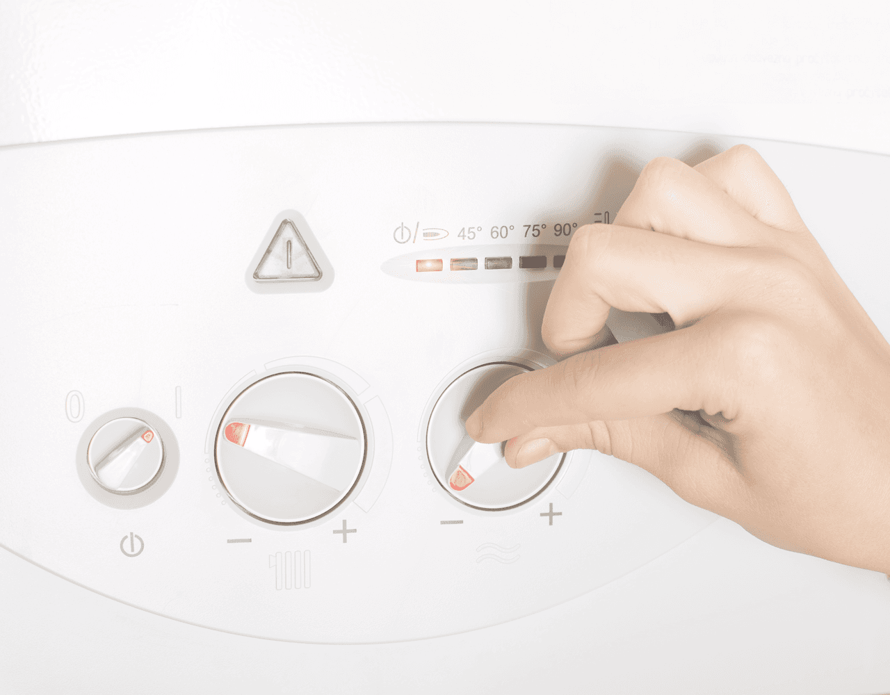 A person is adjusting the temperature on a boiler.